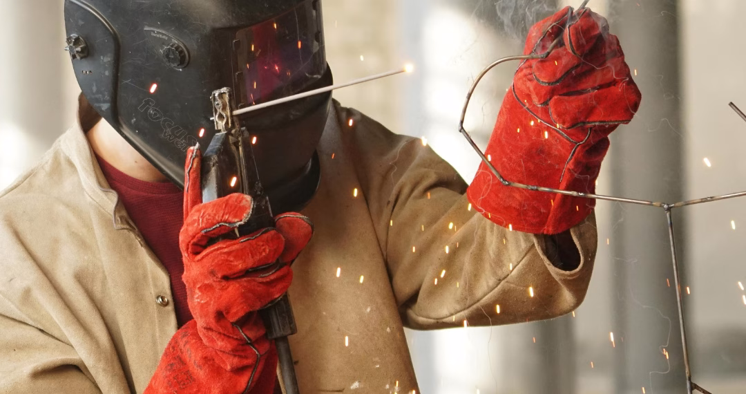 A person doing metal fabrication works